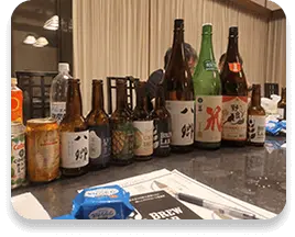 様々なお酒がテーブルに1列に並んでいる写真