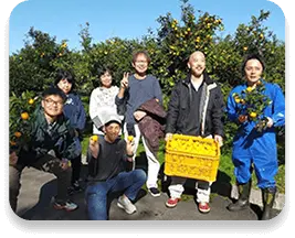 農園で収穫したものを持っている人たちの写真